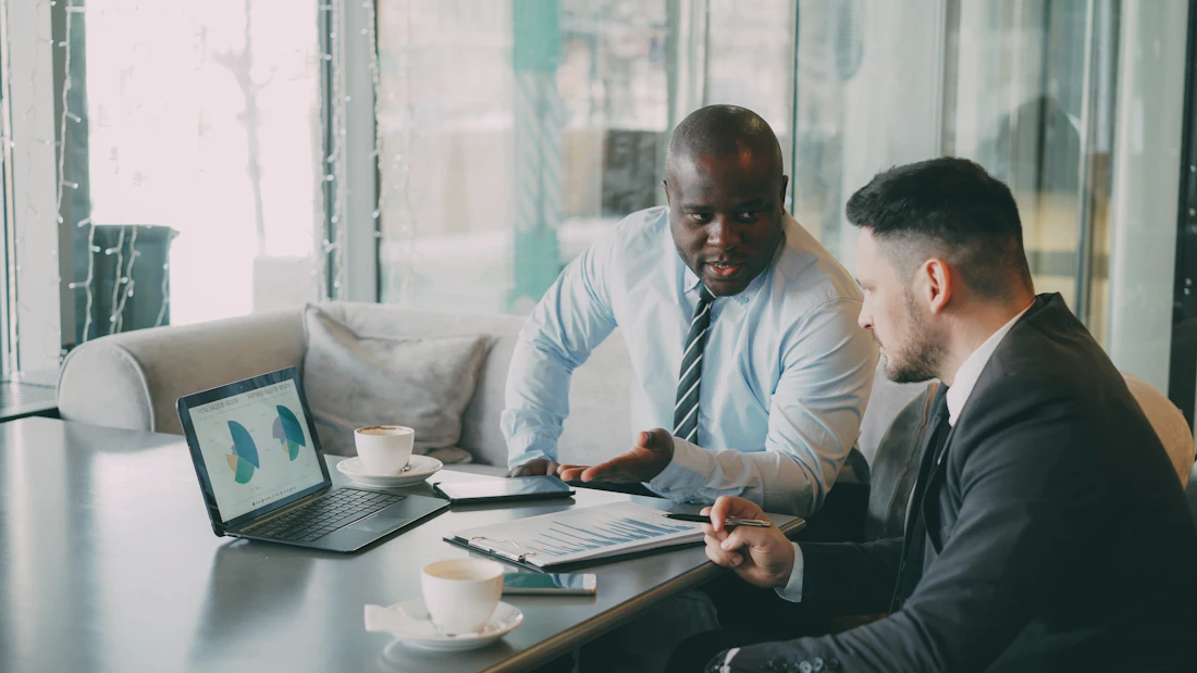 Two business partners reviewing growth charts on a laptop
